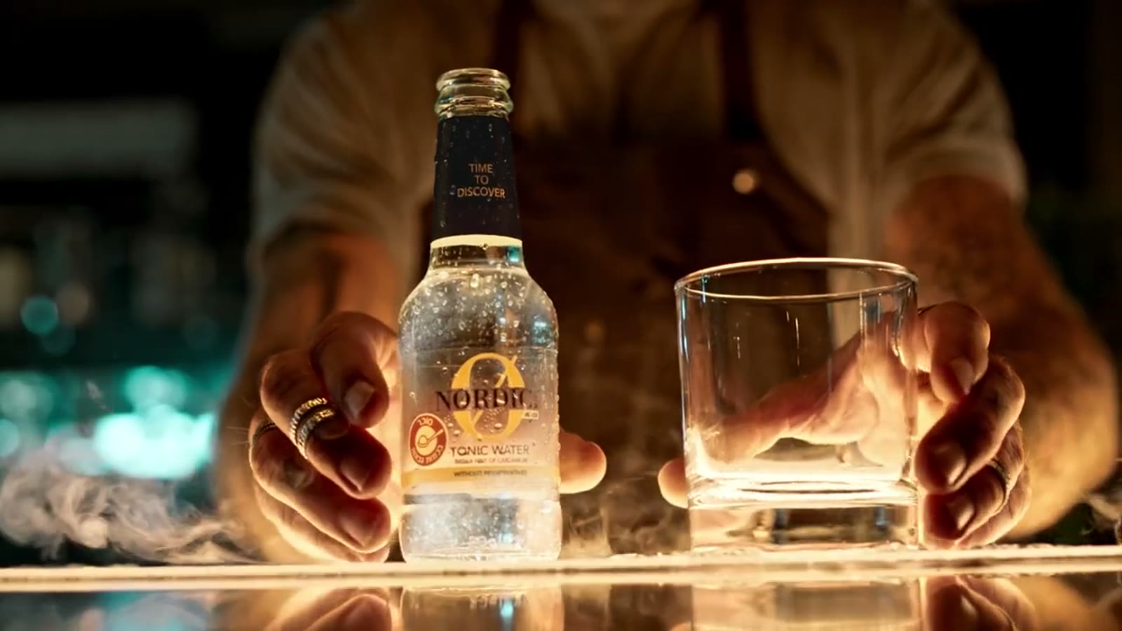 Bartender presenting a bottle of Nordic tonic water.